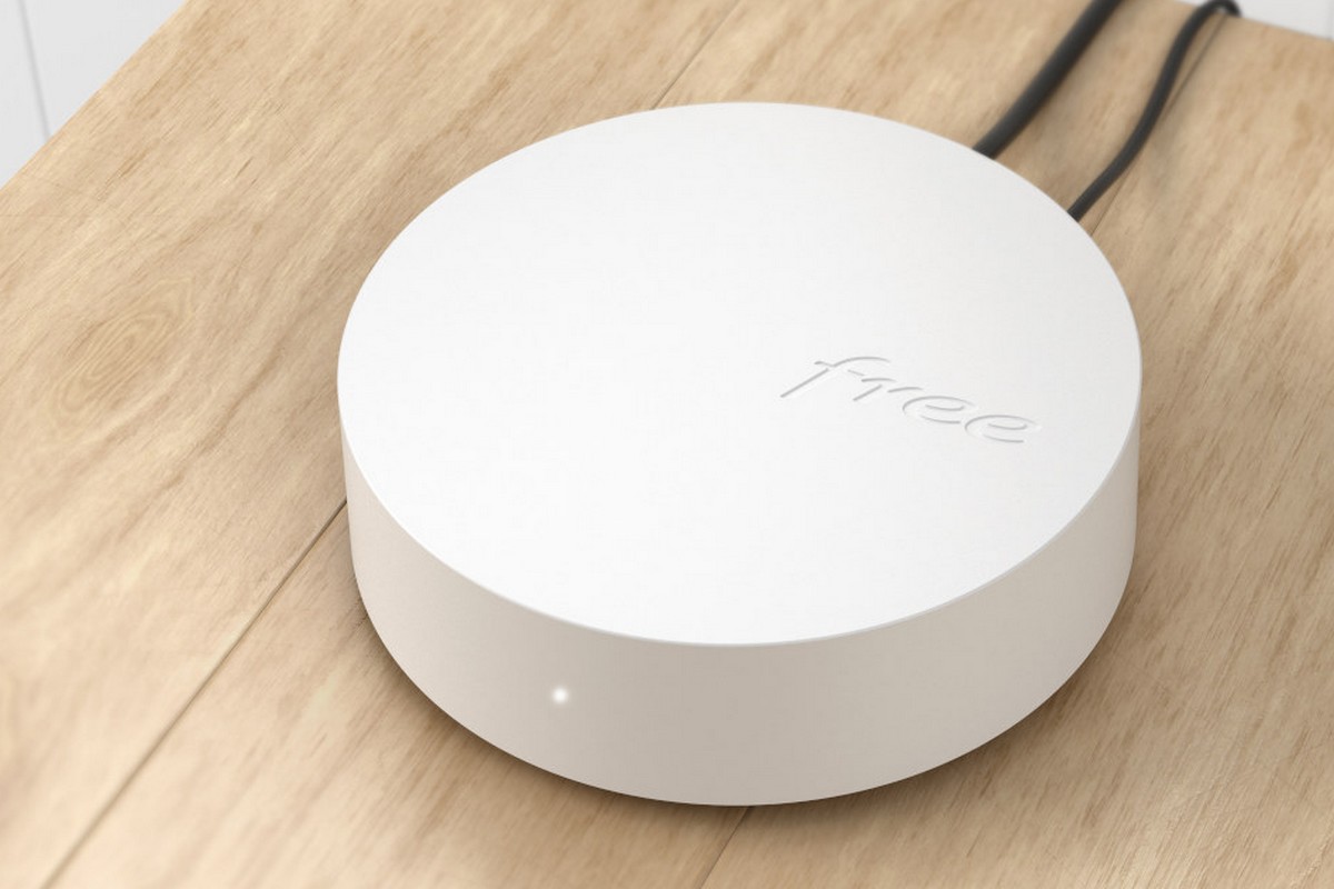 Répéteur Wi-Fi Free branché sur une prise murale à côté d'une Freebox