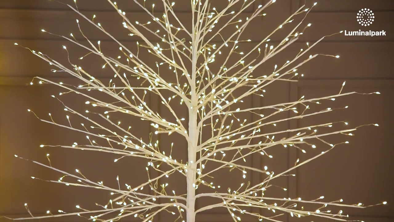 Arbre lumineux LED blanc chaud installé dans un salon près d'une fenêtre